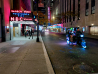 The iconic Radio City by night, 50th street with a pedicab